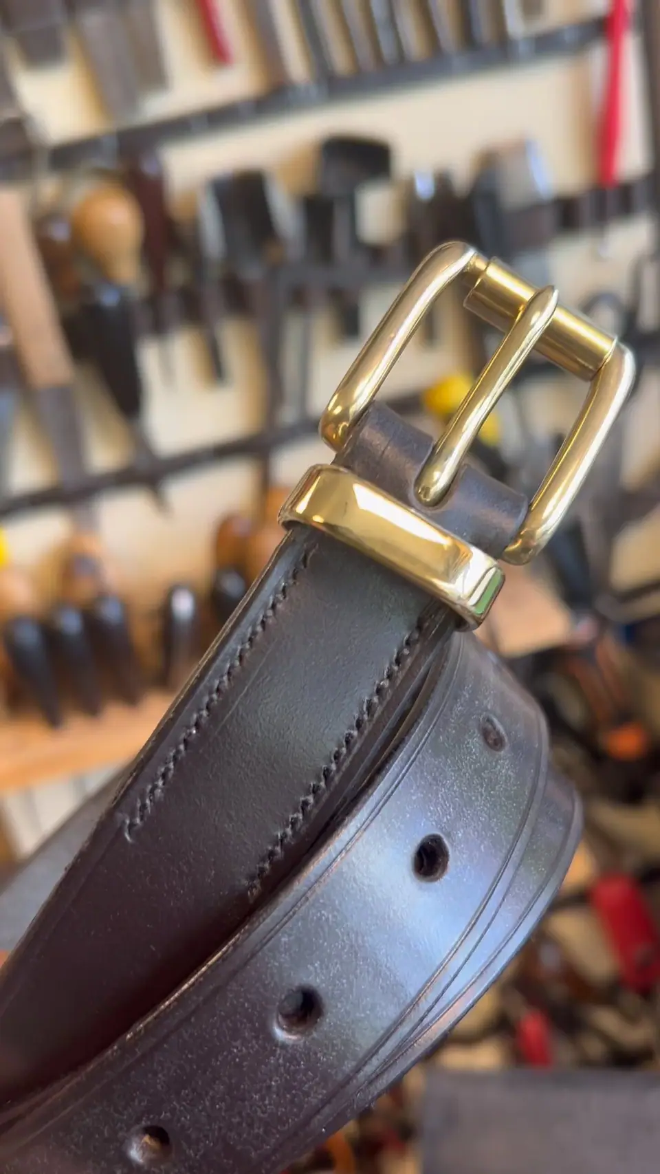 A dark brown belt with a brass buckle