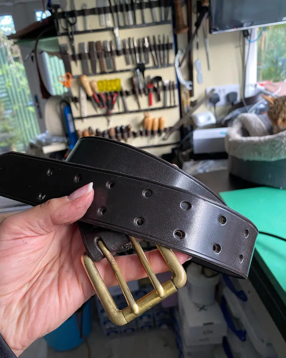 A black belt with a double brass buckle