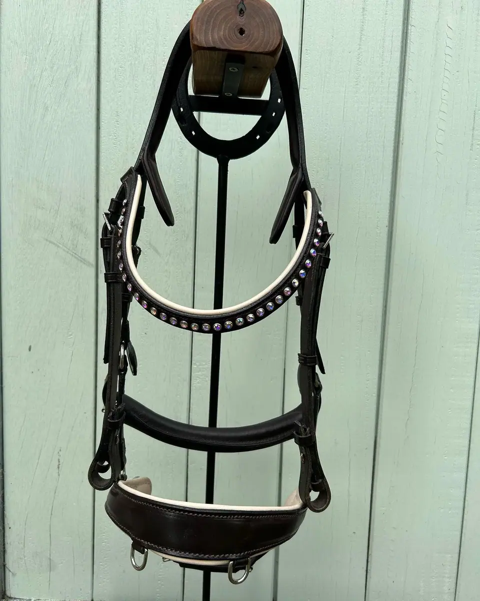 A black bridle with a crystal browband on a stand