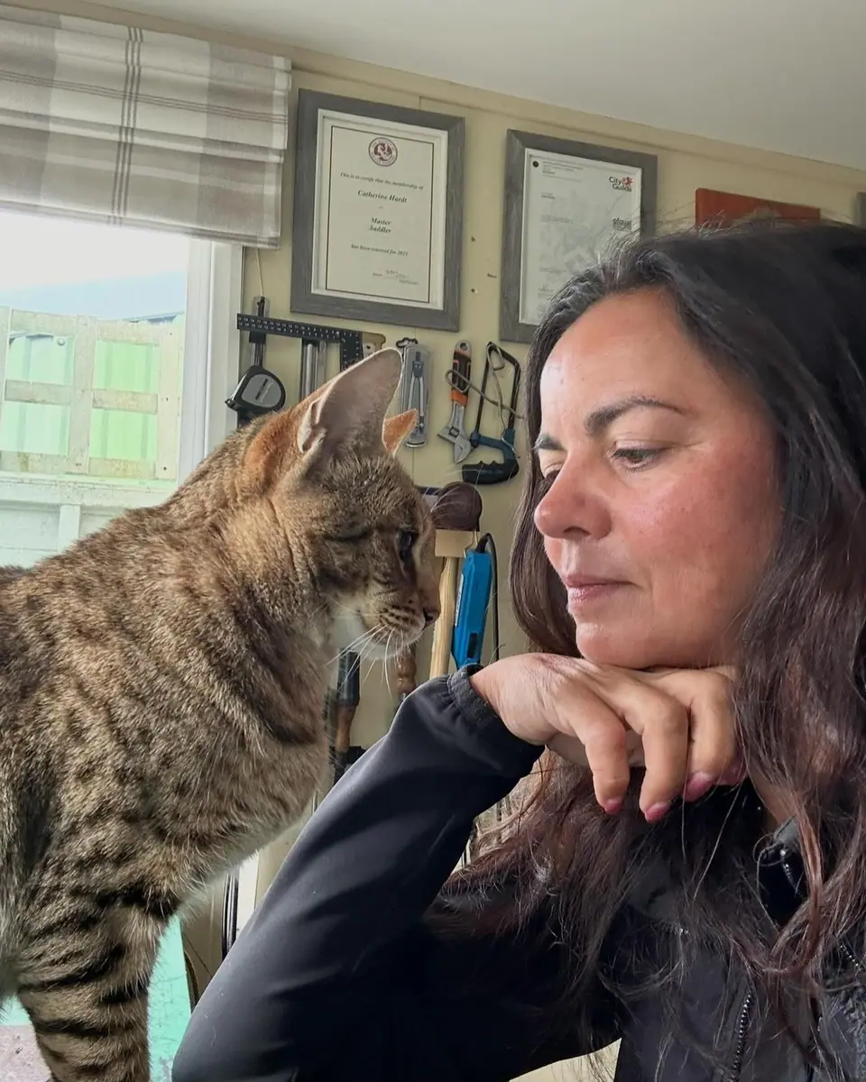 Kate at the workshop window with Kenzo the workshop cat on her shoulder