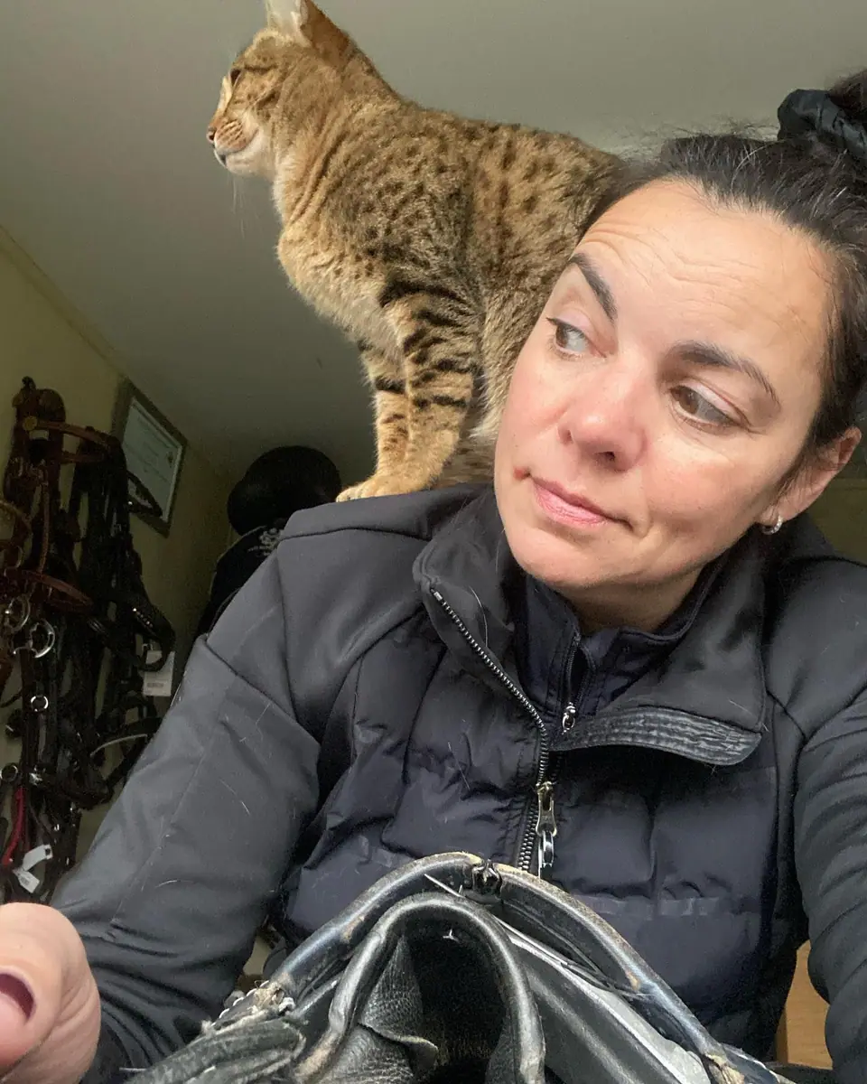 Kate stitching at the bench while Kenzo sits on her shoulder