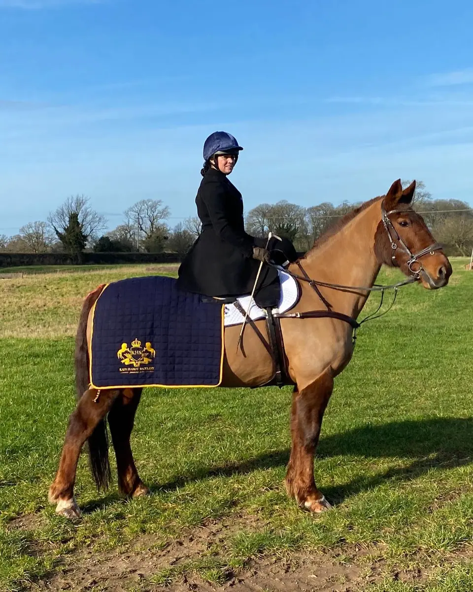 Kate riding side saddle in a field