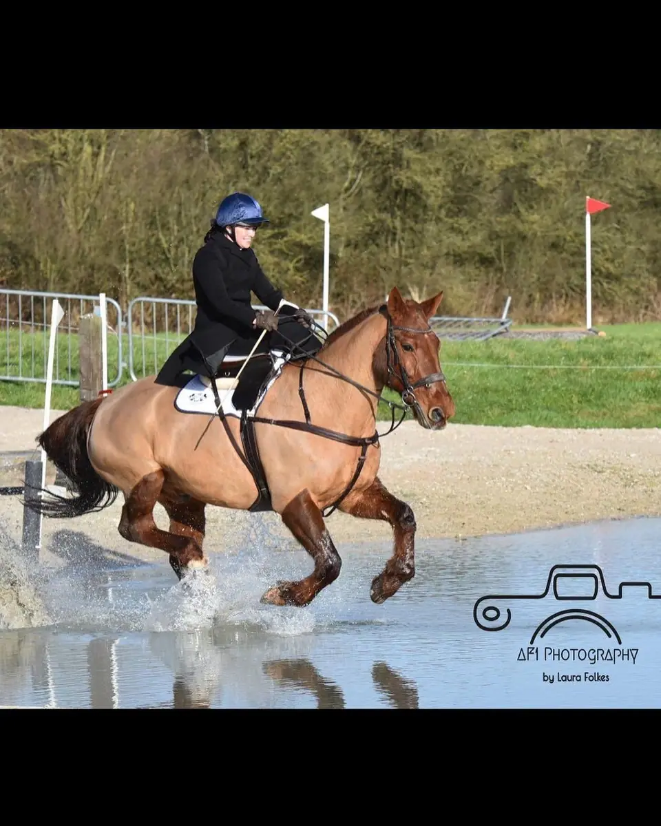 Kate riding side saddle through water on a cross country course